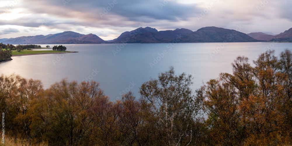 the beautiful kentallen bay in the argyll region of the highlands of scotland near glencoe and fort william in autumn during sunset showing golden trees and cloudy skies