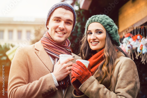 Couple standing on Christmas market in front of gift stall