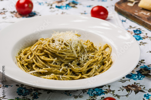 Delicious italian pasta spaghetti with pesto sauce  cherry tomato and cheese. Close up. Italian style