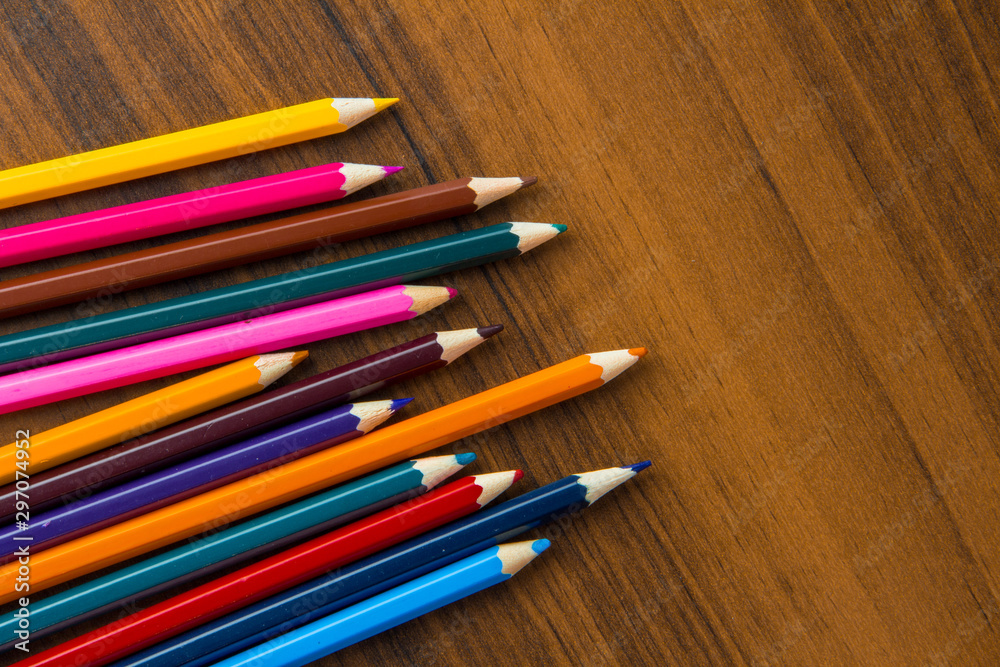 colored pencils on a brown table colored pencils on a brown table