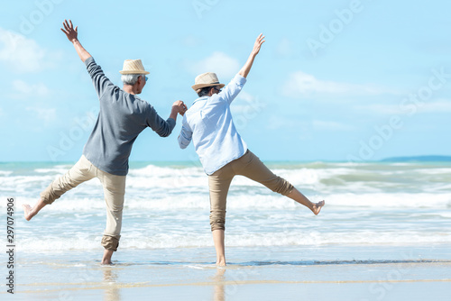 Asian Lifestyle senior couple jumping on the beach happy in love romantic and relax time.  Tourism elderly family travel leisure and activity after retirement in vacations and summer. photo
