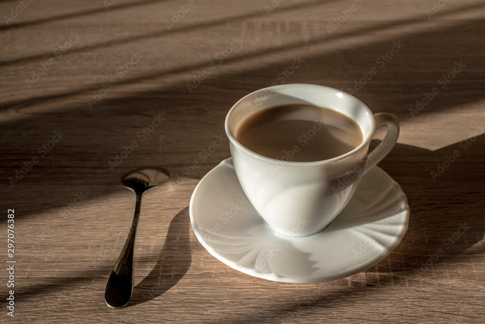 cup of morning latte coffee with saucer and spoon on the table cup of morning latte coffee with saucer and spoon on the table