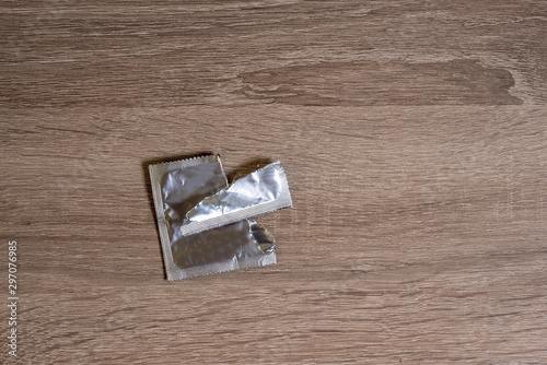open condom packaging lies on a bedside table