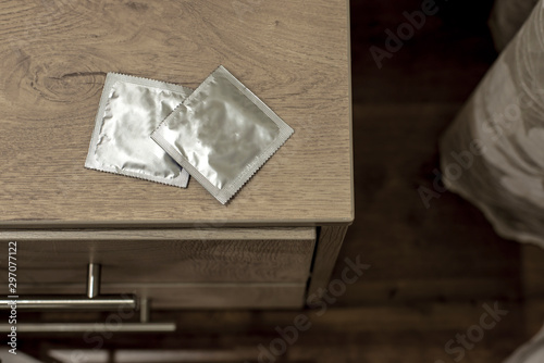 unused condoms lie on the bedside table
