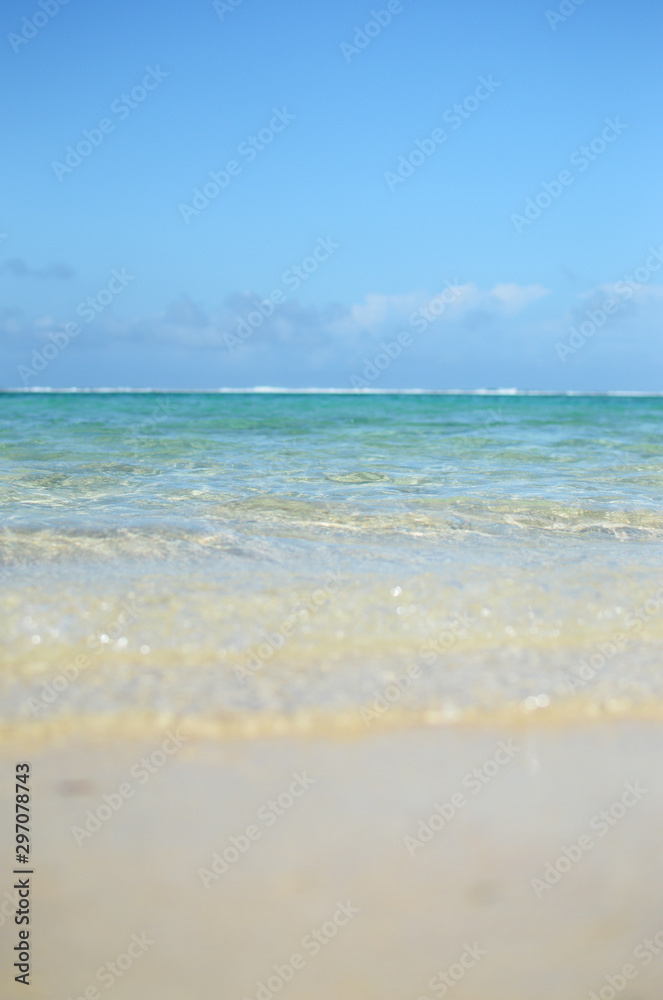 エメラルドグリーンの遠浅の海と砂浜