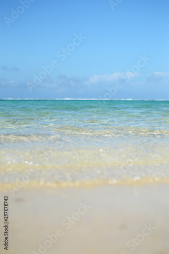 エメラルドグリーンの遠浅の海と砂浜