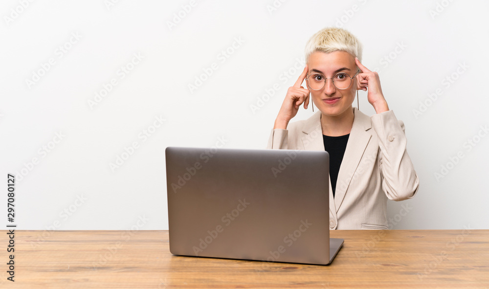 Teenager girl with short hair with a laptop having doubts and thinking Teenager girl with short hair with a laptop having doubts and thinking