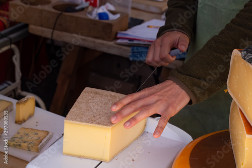 Market stall worker slicing cheese with a wire cutter © magicbones