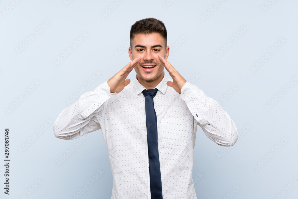 Handsome businessman over isolated blue background shouting with mouth wide open Handsome businessman over isolated blue background shouting with mouth wide open