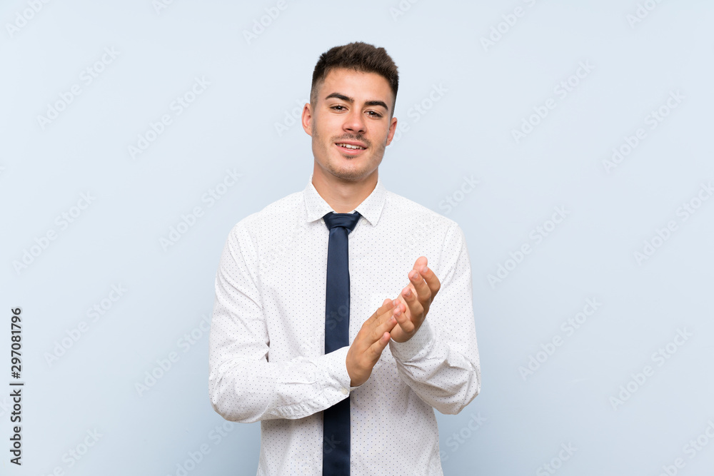 Handsome businessman over isolated blue background applauding