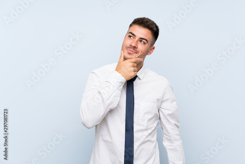 Handsome businessman over isolated blue background thinking an idea