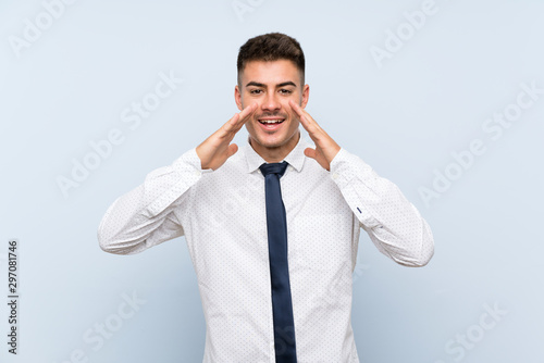 Handsome businessman over isolated blue background shouting with mouth wide open