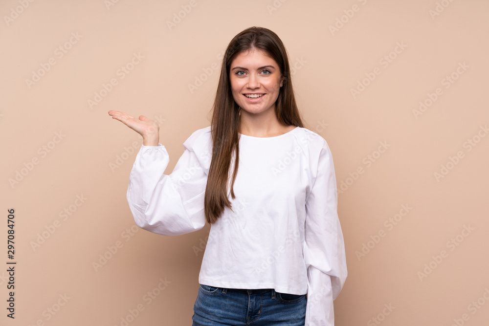 Young girl over isolated background holding copyspace imaginary on the palm to insert an ad Young girl over isolated background holding copyspace imaginary on the palm to insert an ad