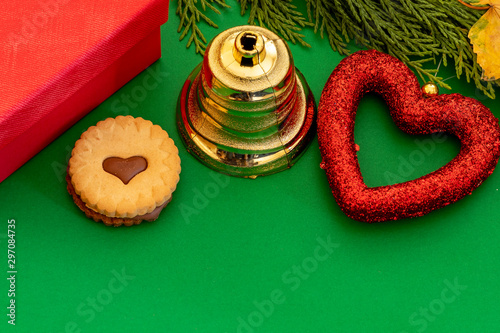 Creative Composition Useful for Christmas and New Year Greeting Card Created Using Red Gift Box, Green Pine Branch, Christmas Bell, Red Heart and Cake