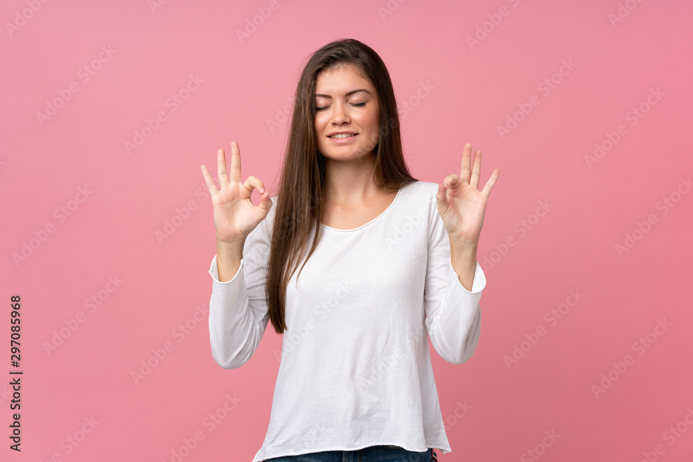 Young woman over isolated pink background in zen pose