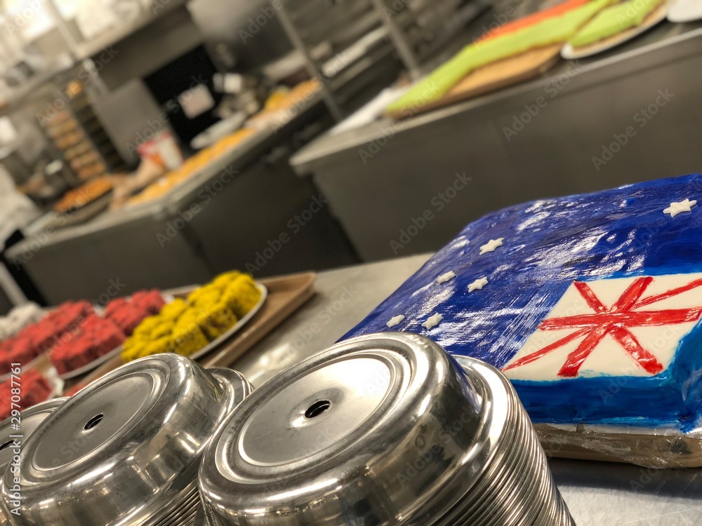 Fototapeta premium Big selection of cakes on the table. Big galley on the cruise ship kitchen, pastry section. Cake with Great Britain flag.