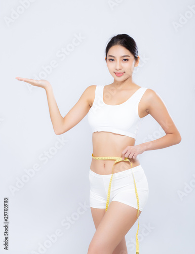 Beautiful asian woman diet and slim with measuring waist for weight presenting something on hand isolated on white background, girl have cellulite loss tape measure, health and wellness concept. © N_studio