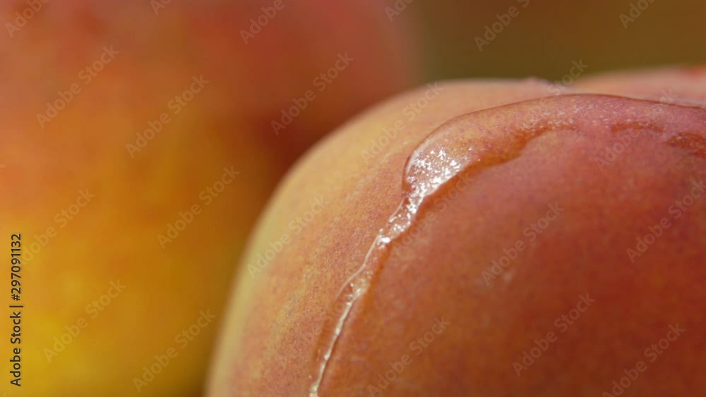 Drop of water flows down the surface of a ripe juicy peach
