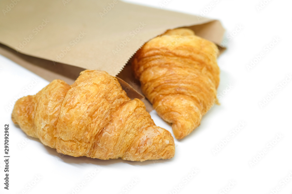 Fresh croissant in brown paper bag on white Background.Tasty buttery croissants.