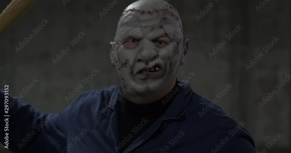 Extremely dangerous man in mask of movie maniac attacks spectator with baseball bat, psycho in parking lot, Halloween holiday, creepy costume, October walk, red ball in his hand, alien from hell Extremely dangerous man in mask of movie maniac attacks spectator with baseball bat, psycho in parking lot, Halloween holiday, creepy costume, October walk, red ball in his hand, alien from hell