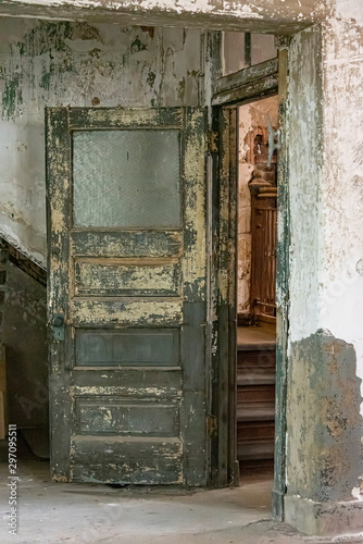 USA, New York, Ellis Island - May 2019: Pin flaking off an old interior door in an abandoned building