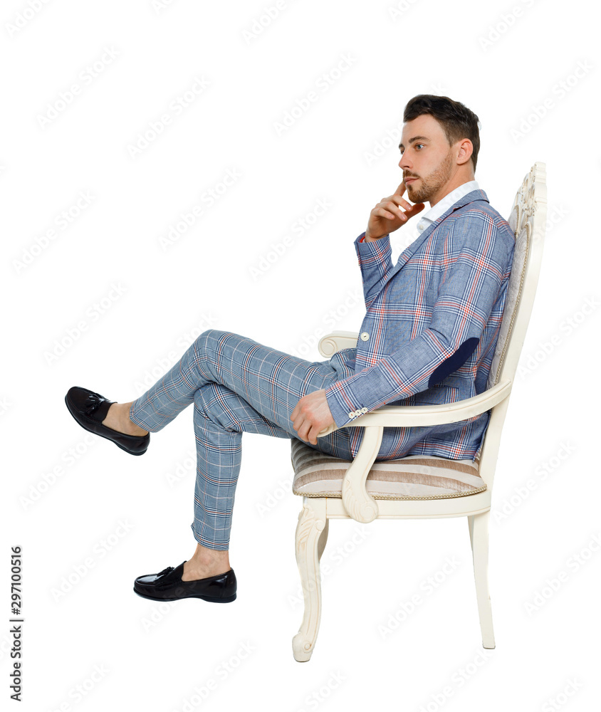 A man in a suit is sitting on an expensive chair.