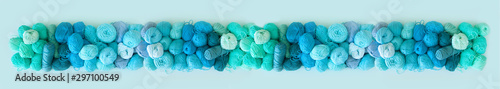 Skein of aquamarine yarn and knitting needles. Crochet hooks. Long background.