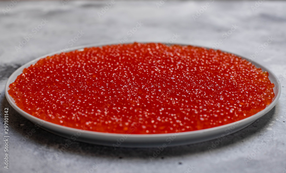 dish with fresh red caviar, close-up. expensive delicacies salty from the sea. light background dish with fresh red caviar, close-up. expensive delicacies salty from the sea. light background