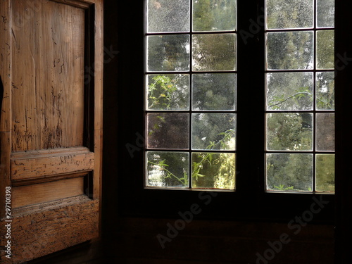 Ancient window with leaded glass and wooden shutters.