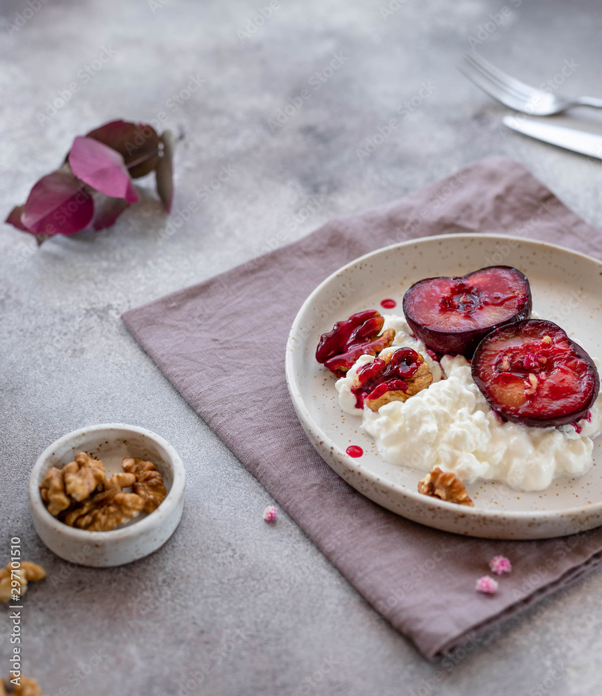 delicious breakfast, yogurt with fruits and nuts in a ceramic plate. gray concrete background delicious breakfast, yogurt with fruits and nuts in a ceramic plate. gray concrete background