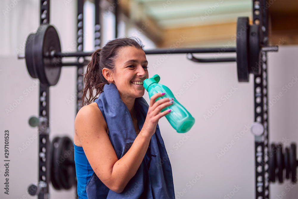 Smiling sports girl drinks water sitting Smiling sports girl drinks water sitting