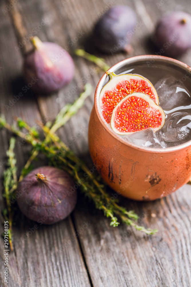 Moscow mule cocktail with figs and thyme on the rustic background. Selective focus. Shallow depth of field.