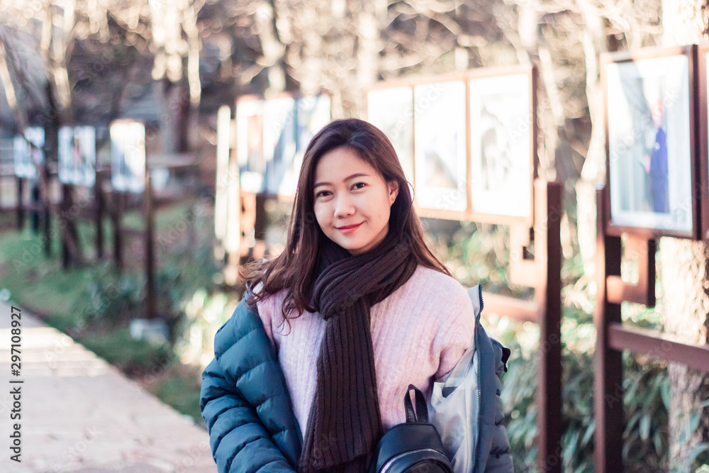 Fototapeta premium Beautiful young Asian woman in her winter jacket, traveler concept.