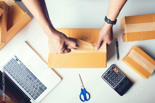 Shipment Online Sales .Man worker delivery service and working packing box, business owner working checking order to confirm before sending customer in post.Top view