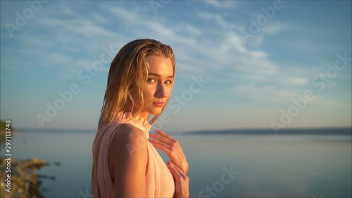 Young girl with a confident look at dawn by the lake