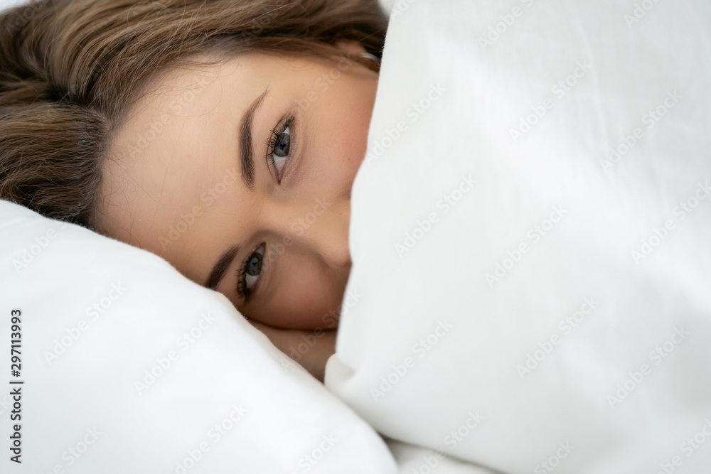 Obraz premium Tranquil pretty young lady covering her face with a blanket