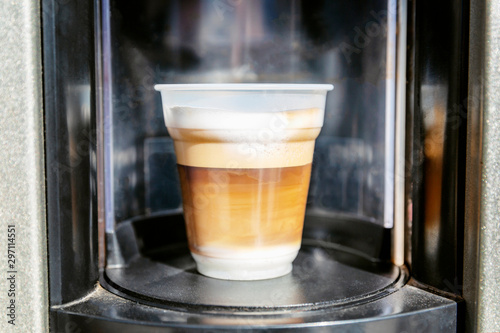 Appetizing coffee in a plastic cup from the machine. Close-up.