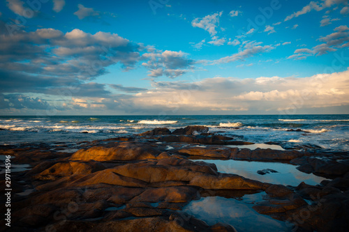 Coastal rocky landscape. Rocks at the edge of the sea. Beautiful clouds