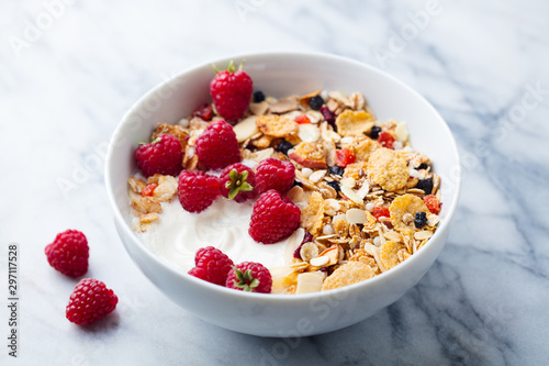 Healthy breakfast. Fresh granola, muesli with yogurt and berries. Marble background. Close up.