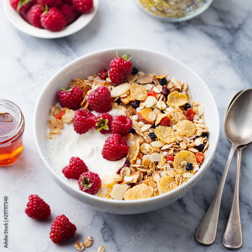 Healthy breakfast. Fresh granola, muesli with yogurt and berries. Marble background. Close up.
