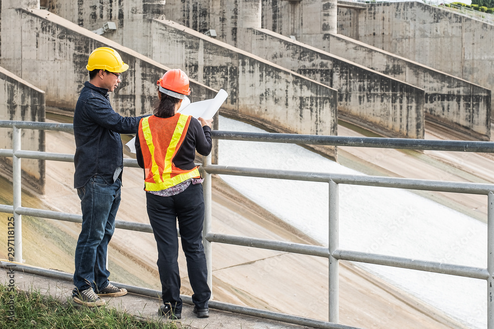 Engineering team Men and woman meeting with Engineers and supervisors are standing reading the blueprints at the construction site. Engineering team Men and woman meeting with Engineers and supervisors are standing reading the blueprints at the construction site.