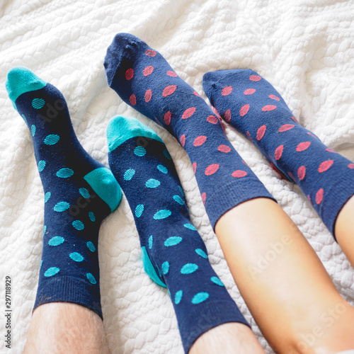 Young couple posing for a selfie feet wearing blue and white polka dotted socks. Square format.