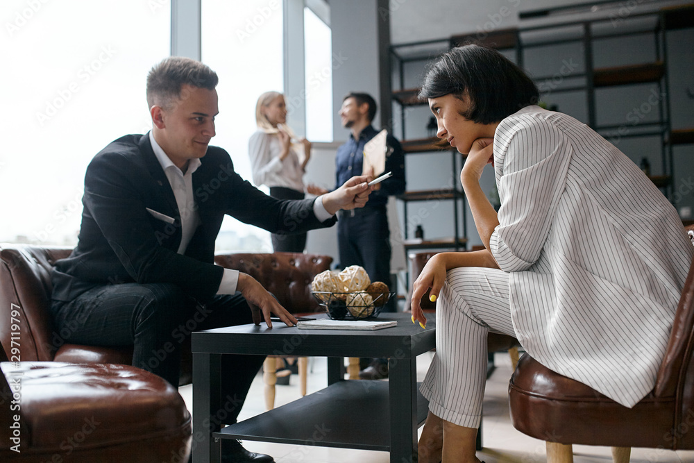 Φωτογραφία cunning businesswoman asking woman to sign the documant, sly business plan, man giving a pen to puzzled brunette woman who is hesitating to write on the notepad