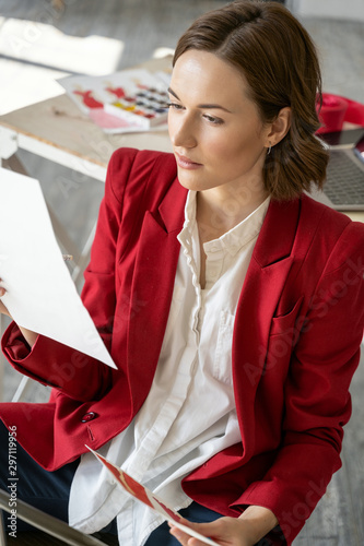 Young woman looking at her sketches in a workshop