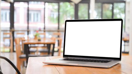 Laptop computer on wooden table with empty screen.