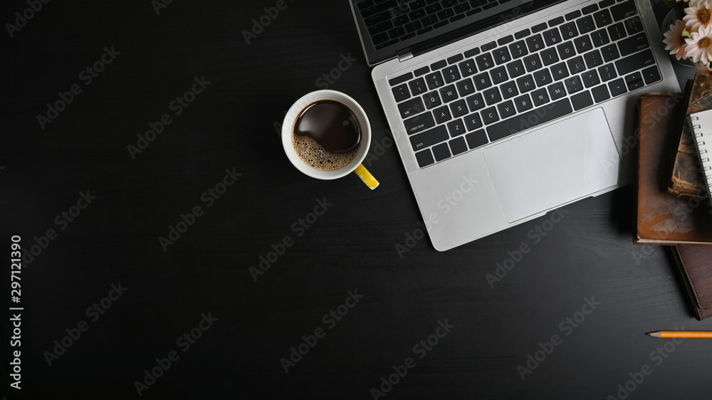 Fototapeta Płaskie biurko z widokiem z góry. Obszar roboczy z laptopa i materiałów biurowych na czarnym stole.