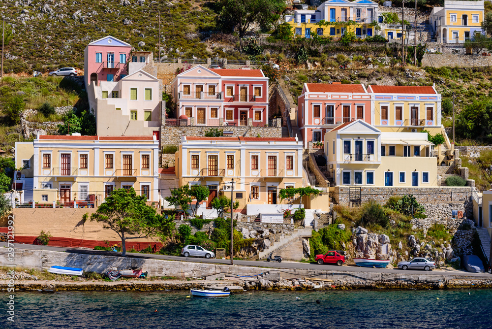 Sightseeing of Greece. Cityscape of Symi island. Traditional bright facades of buildings on the coastline of Symi island 