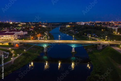 The embankment, the Neman river and the Old bridge in Grodno. Autumn ,evening, the city in the sunshine against a background of dark clouds