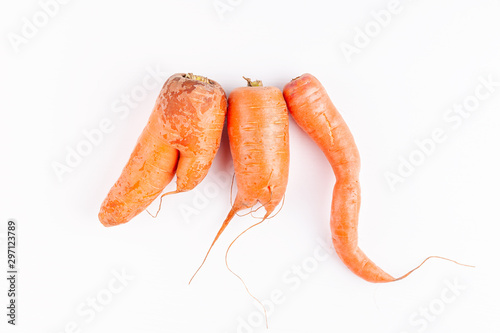 Funny ugly vegetables, carrots on white background. Concept of zero waste production in food industry. Top view.
