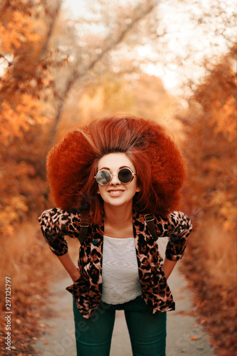 Woman with afro walks in the Park in autumn.
